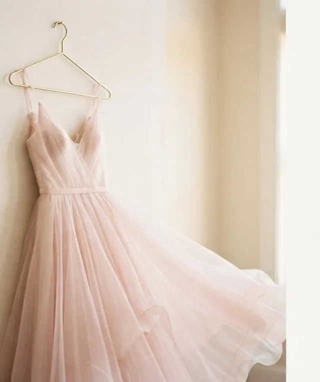 Flowing blush pink dress on a hanger